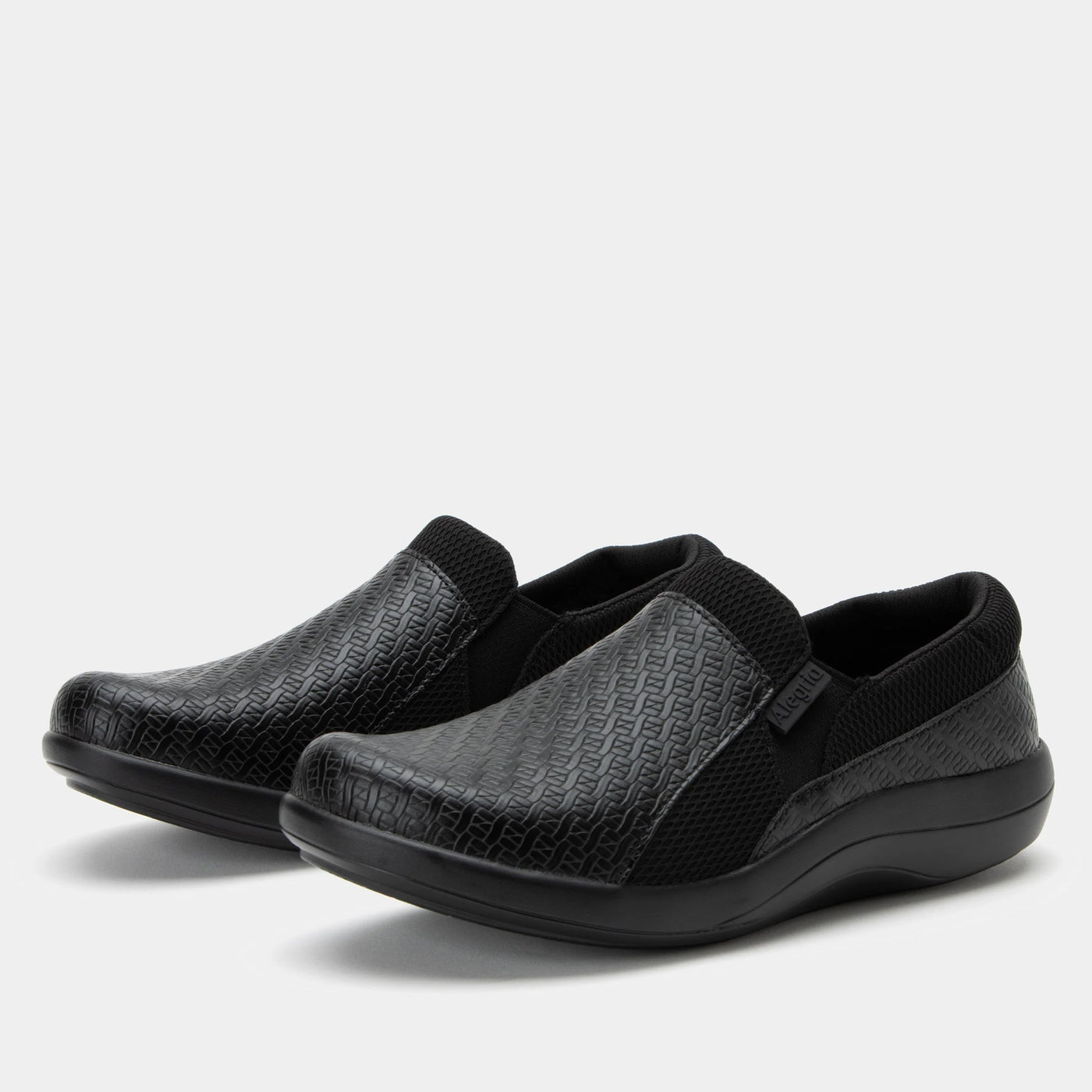 Alegria Women’s Duette slip-on in black woven vegan leather with elastic gores, padded collar, cushioned removable footbed, and slip-resistant sport rocker outsole.