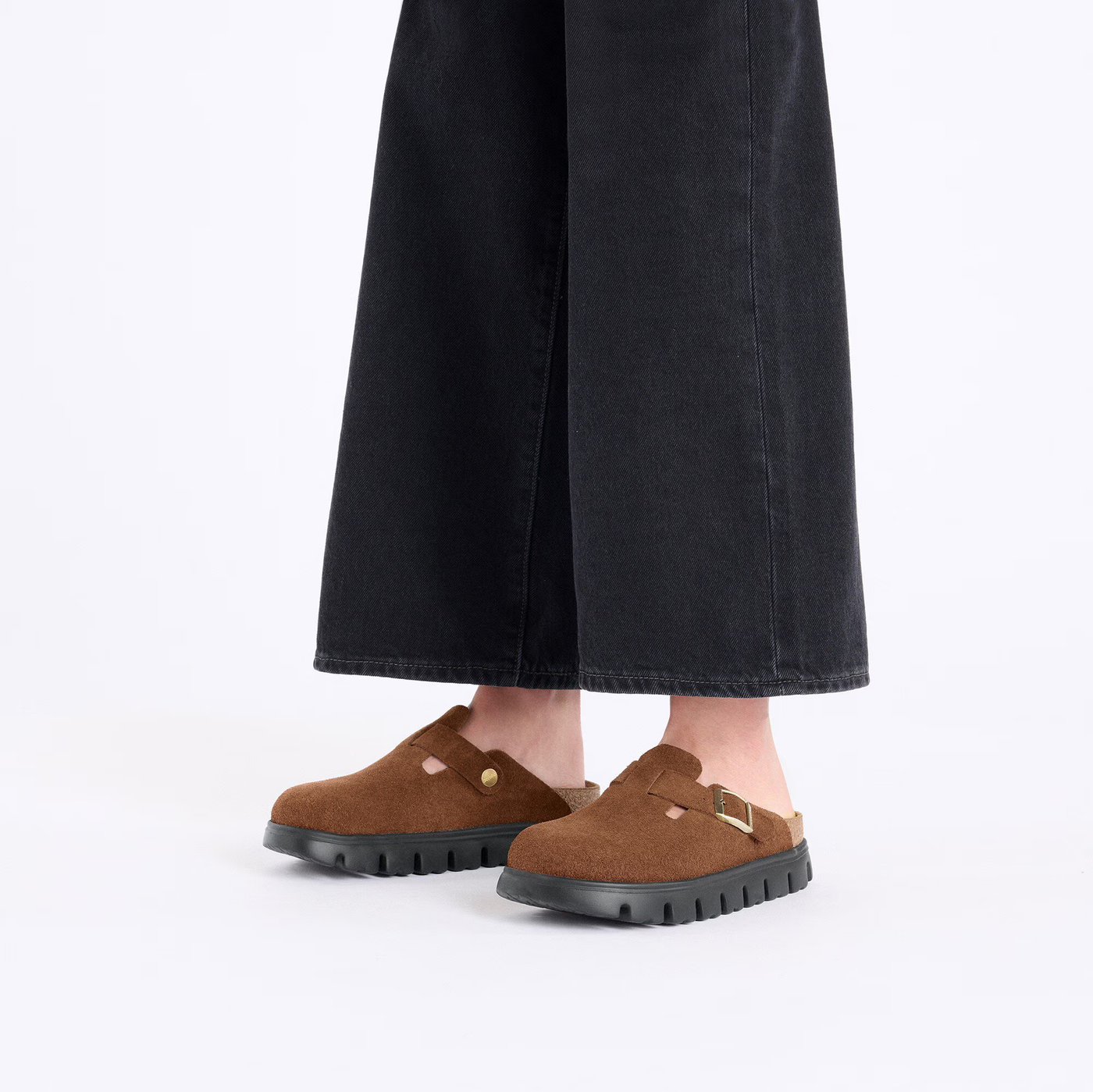 Model wearing Birkenstock Boston Chunky clogs in dark tea suede with black wide-leg pants for a casual look.