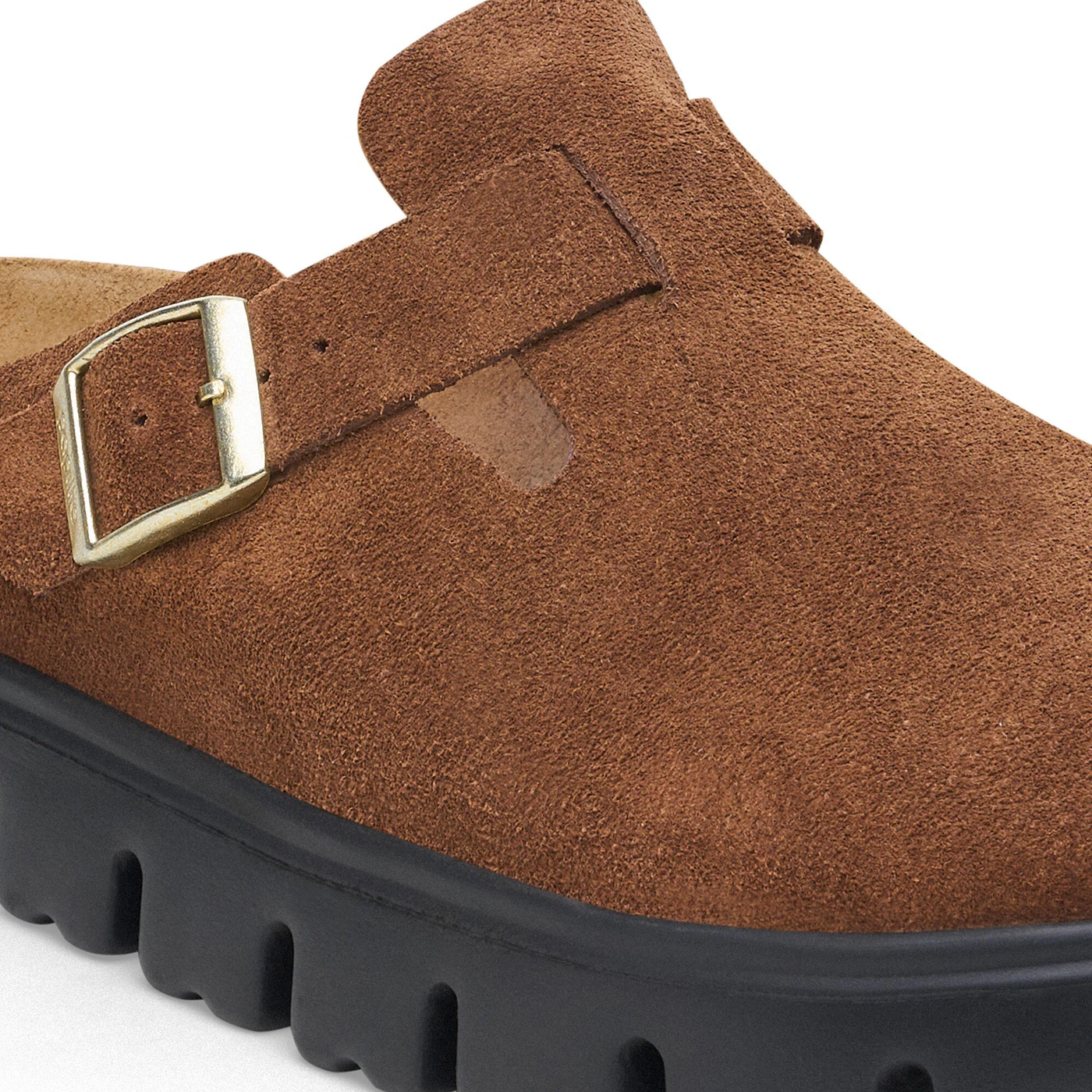 Close-up detail of Birkenstock Boston Chunky clog in dark tea suede with a black sole and gold buckle.