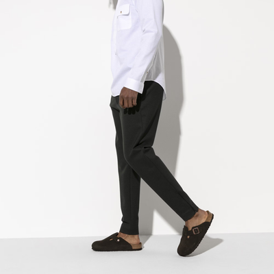 Man in white shirt and black pants wearing mocha Birkenstock Boston clogs with cork-latex soles.