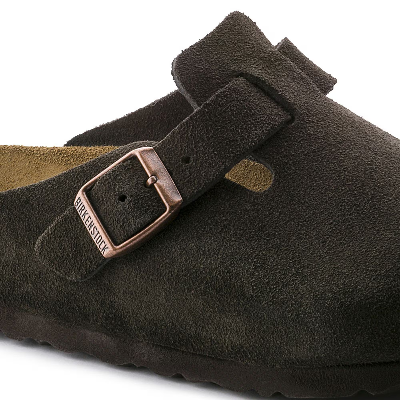 Close view of a Birkenstock Boston clog in mocha suede with an adjustable strap featuring a metal buckle, soft footbed, and cork-latex sole for comfort and support.