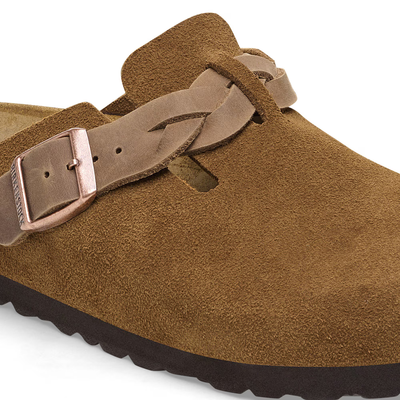 Close view of Birkenstock Boston clogs in mink suede with braided straps, metal buckles, and cork-latex footbeds.