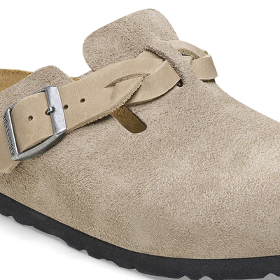 Close-up detail of the Birkenstock Boston clog in taupe suede, featuring a braided strap and metal buckle.