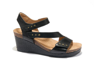 Black leather wedge sandal with adjustable hook-and-loop straps, bronze stud accents, tan cushioned footbed, and textured 2-inch wedge heel.