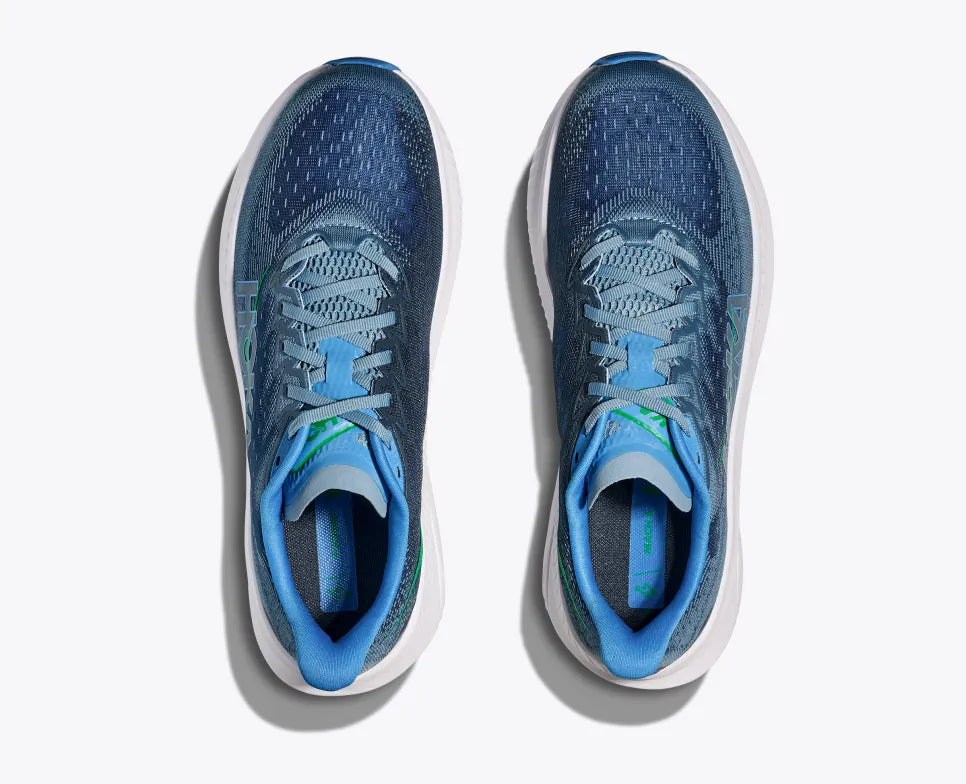 Top-down view of a pair of blue HOKA Mach 6 running shoes with breathable mesh uppers, light blue laces, green accents on the insoles, and a thick white cushioned sole with blue detailing for performance and comfort.