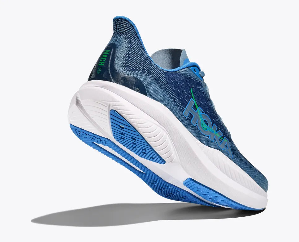 Angled side view of a blue HOKA Mach 6 running shoe with breathable mesh uppers, a bright blue and green HOKA logo on the side, and a thick white cushioned sole with blue detailing for enhanced performance and comfort.