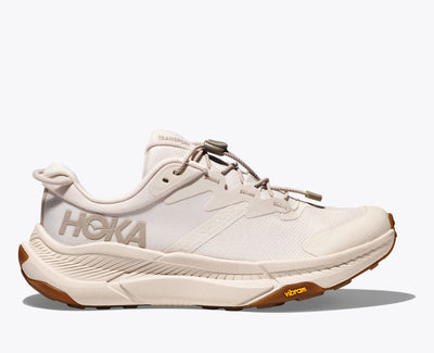 Cream HOKA Transport sneaker with Vibram® sole, quick-toggle laces, and Cordura® mesh upper, designed for commuting, hiking, and walking with sustainable materials throughout.