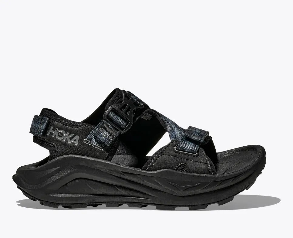 HOKA Infini Hike men sandal in black, featuring adjustable quick-dry straps, Ariaprene® upper, dual-density midsole, deep heel cup, and Vibram® Megagrip outsole for traction on various terrains.