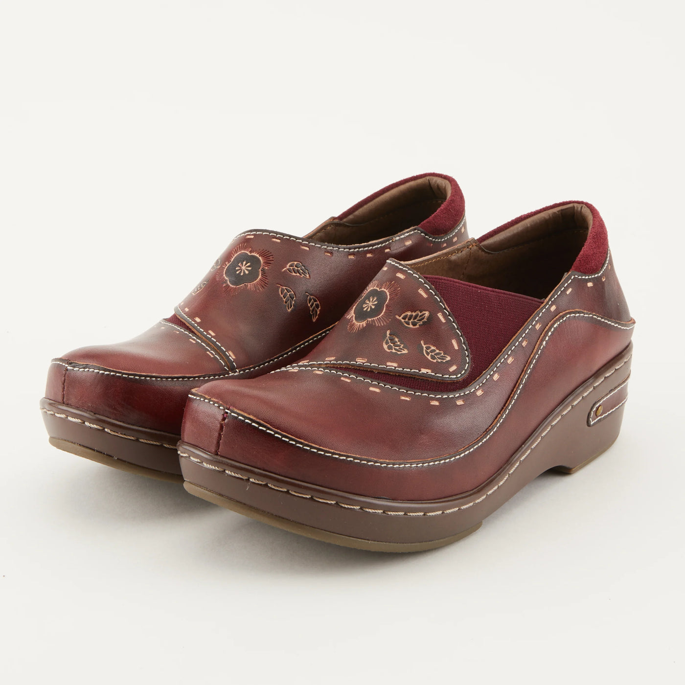 L’Artiste Women’s Burbank Bordeaux leather clogs with hand-painted floral design, elastic sides, and contrast stitching on a comfort platform sole.