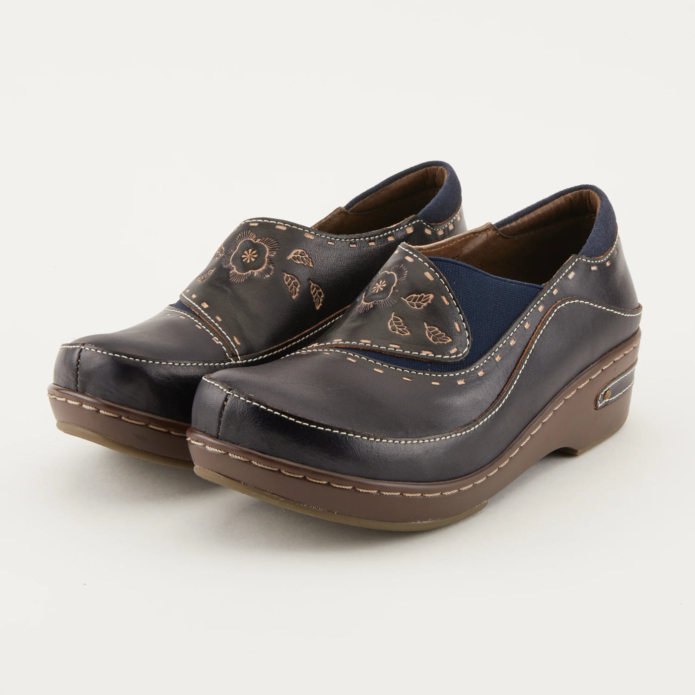 Women’s L’Artiste Burbank navy closed-back clogs with floral embossed leather, cushioned insole, and 2-inch comfort heel.