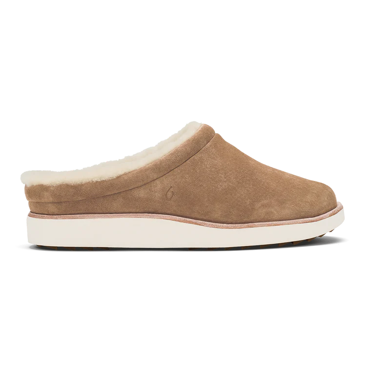 OluKai Women’s Mani slipper in tan golden sand nubuck leather with plush shearling lining and white rubber sole for cozy indoor and outdoor comfort.