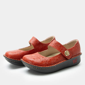 Pair of Mary Jane shoes in a Coralita colorway with a laser-etched leather upper, adjustable hook-and-loop strap with a decorative ornament, memory foam and cork footbed, and classic rocker outsole.