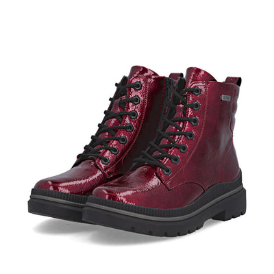 Remonte Women’s Zip Boot in glossy Red Patent with lace-up front, side zipper, and water-resistant vegan design featuring warm lining and grippy sole.