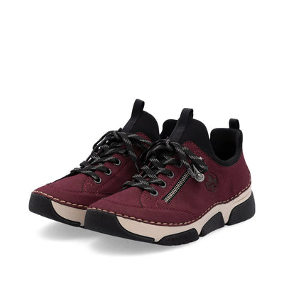 Rieker Women’s Burgundy oxford sneakers with side zipper, black laces, and cushioned Riricon sole for comfort and shock absorption.