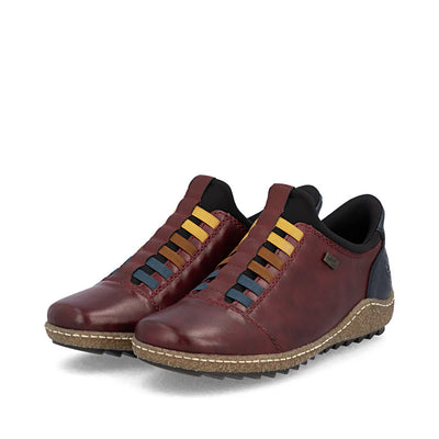 Rieker Women’s Vino leather slip-on shoes with colorful elastic bands, textured sole, and water-repellent comfort design for everyday wear.