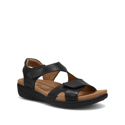 Black leather sandal with hook-and-loop straps, cushioned microfiber footbed, arch and metatarsal support, and a low wedge heel on a flexible black rubber outsole.