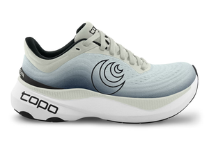 Side view of a light gray Topo running shoe with a gradient design fading into charcoal, featuring a black swirl logo on the side, 'topo' branding on the sole, and a thick white cushioned sole for comfort and performance.