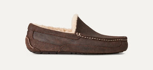 Brown suede UGG Ascot slip-on with moc-toe stitching, cozy wool-blend UGGplush lining, and treaded rubber outsole; side profile