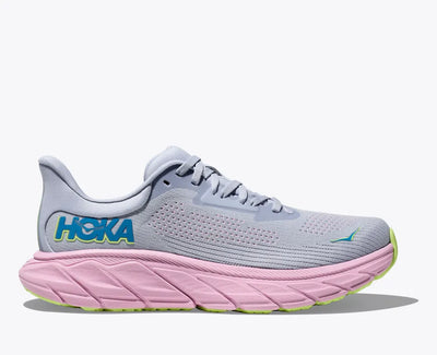 HOKA Arahi 7 stability running shoe in light gray with a pink midsole and blue logo, featuring J-Frame™ support technology, a flat knit upper, and plush cushioning for everyday runs and walking.