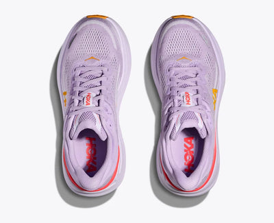 Top-down view of a pair of lavender HOKA running shoes with breathable mesh uppers, orange and red accents, and the HOKA logo visible on the insoles, featuring a lightweight and cushioned design.