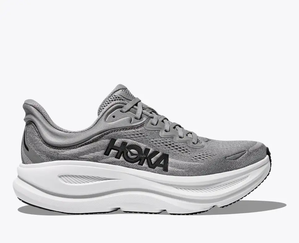 Side view of a gray HOKA running shoe with breathable mesh uppers, black HOKA logo on the side, and a thick white cushioned sole for comfort and support.