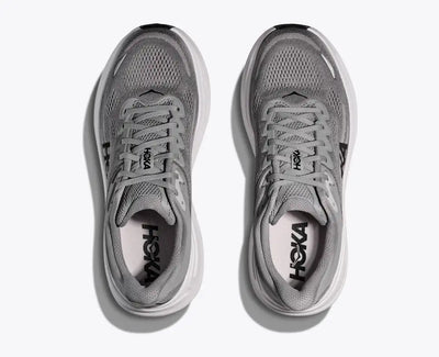 Top-down view of a pair of gray HOKA running shoes with breathable mesh uppers, black HOKA logos on the insoles, and a thick white cushioned sole for a comfortable and lightweight design.