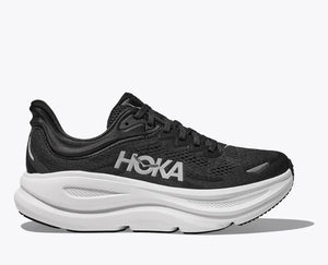 Side view of a black HOKA running shoe with breathable mesh uppers, white HOKA logo, and a thick white cushioned sole designed for comfort and support.