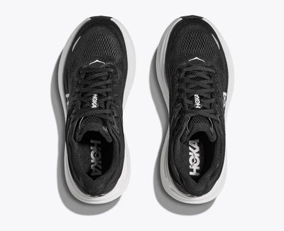 Top-down view of a pair of black HOKA running shoes with breathable mesh uppers, white HOKA logos on the insoles, and thick white cushioned soles for comfort and performance.