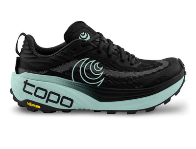 Topo trail runner in black with mint midsole—max-cushion ZipFoam (38/33mm), rocker profile, and Vibram Megagrip outsole with 4mm lugs; side view, gaiter-compatible.