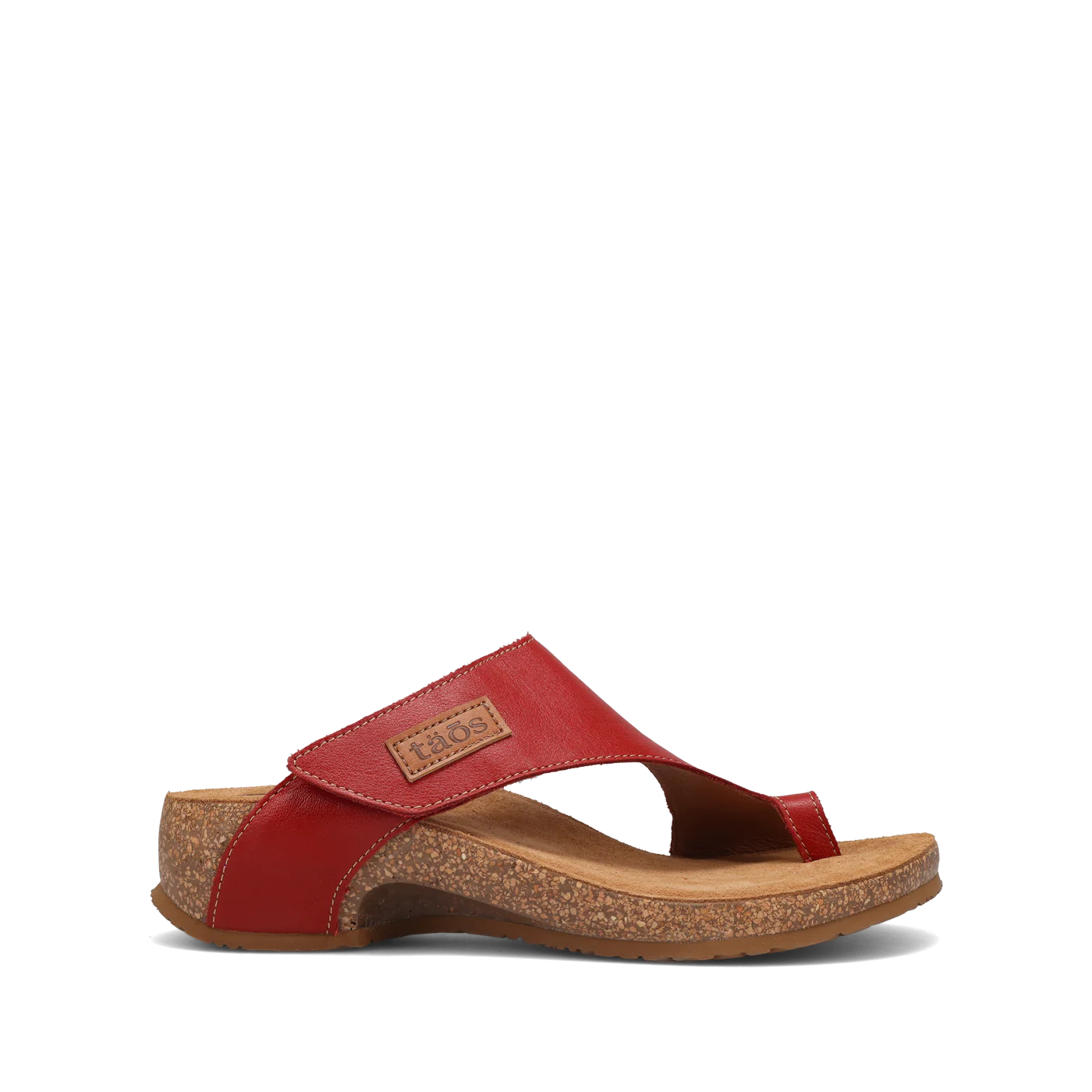 Side view of a pair of red Taos sandals featuring a slip-on design with a soft suede footbed and subtle stitching details.