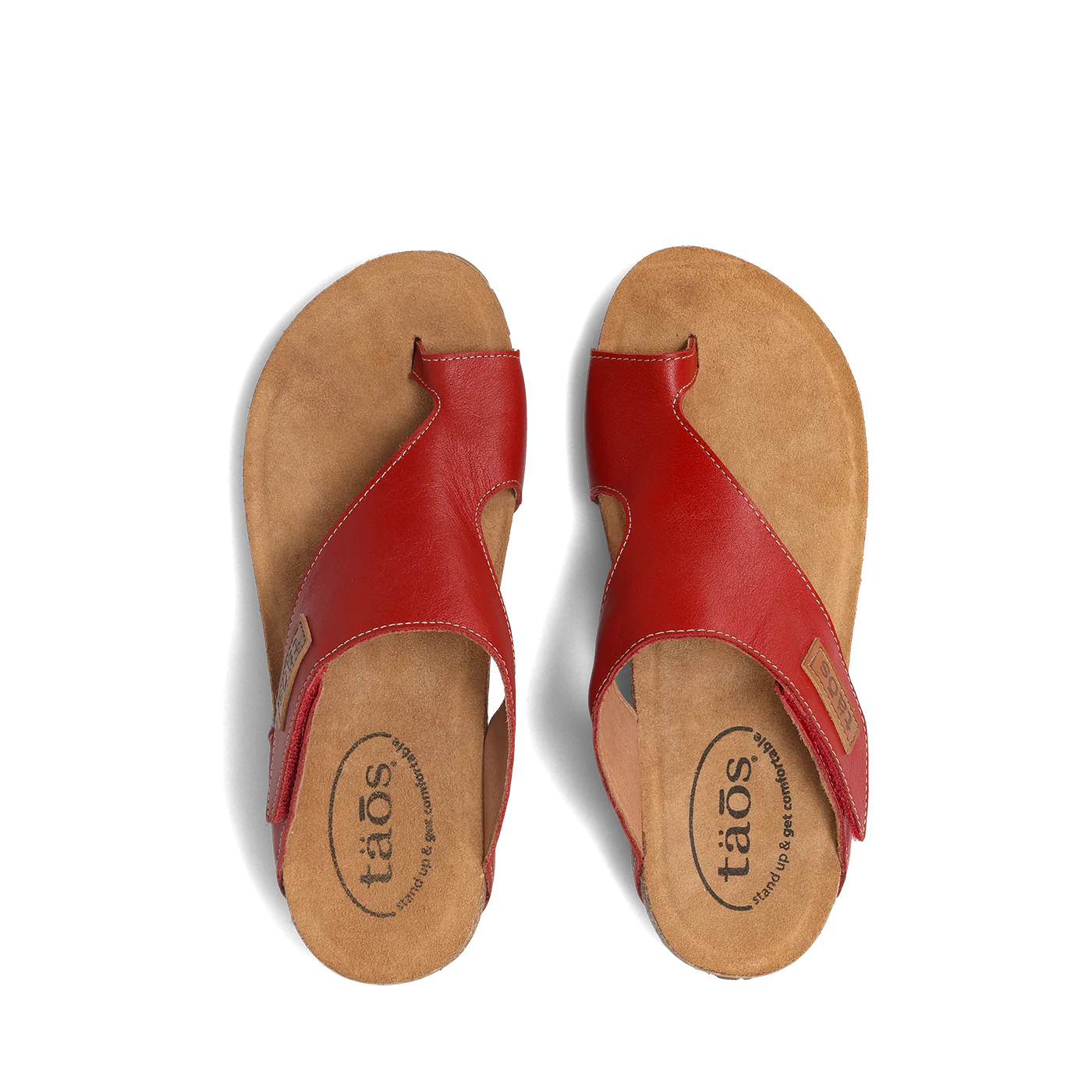 Top view of a pair of red Taos sandals featuring a slip-on design with a soft suede footbed and subtle stitching details.