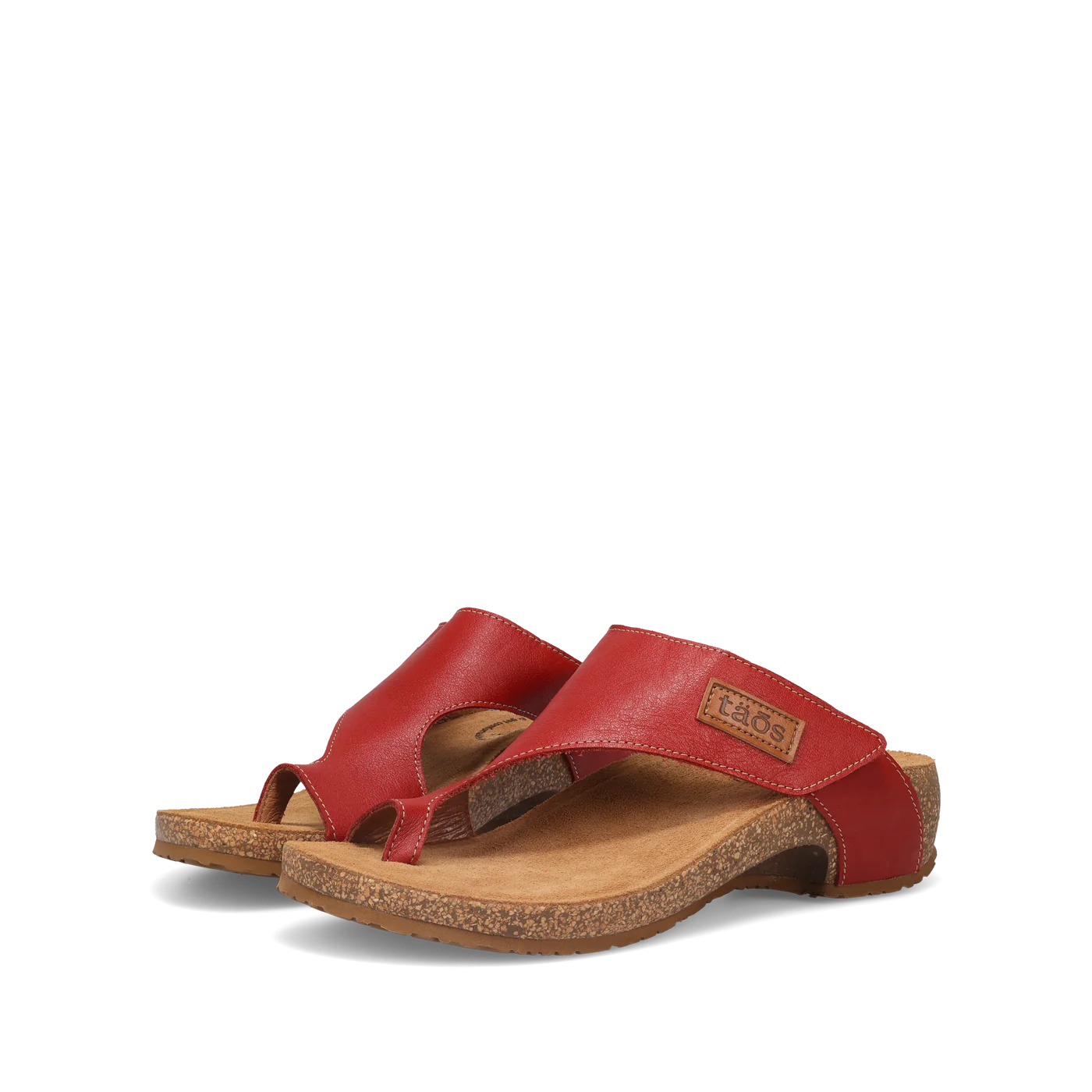 Side view of a pair of red Taos sandals featuring a slip-on design with a soft suede footbed and subtle stitching details.